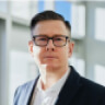 Headshot of a man in glasses and a suit.