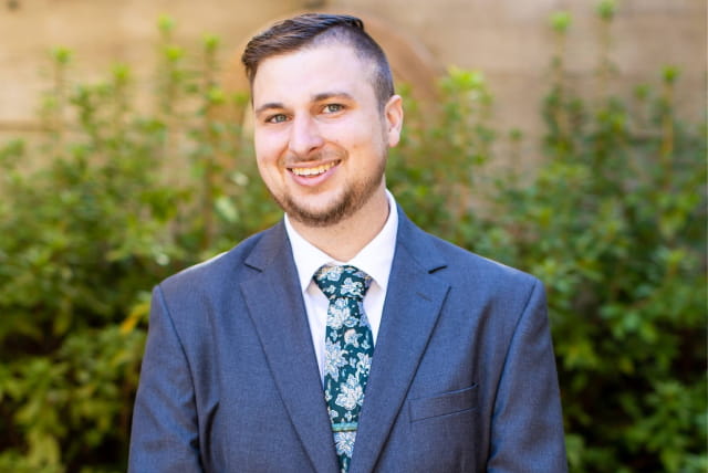 Man smiling in a suit and tie.